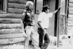 Southern Ute tribal members, Howard Richards Sr. (left) with the Ignacio Police Department, and Dewitte Baker of Southern Ute Fish & Game Dept. catch up outside of the Recreation Hall adjacent to Ute Park, circa 1984. 