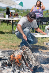Chef M. Karlos Baca prepares part of the lunch menu on a fire pit at the 4th World Farm in Mancos, Colo.
