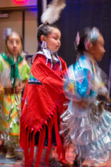 Fancy dancer, Shayne WhiteThunder makes her way into the “grand entry” with jingle dress dancers, Mia Lopez and Olyvia Watts. 