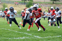 Keenan Rand (30) a fifth grader for the Durango Demons gets some yardage before a Cortez Panther brings him down short of the end zone at Miller Middle School Saturday, Aug. 24 in Durango, Colo.