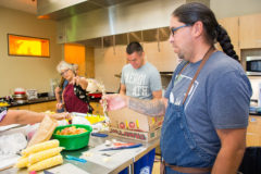 Karlos Baca with Taste of Native Cuisine shows the participants how to cook the traditional meal, which was served to the Southern Ute community on Thursday, Aug. 22. Baca along with Shane Burnette of Partnership with Native Americans helped all of the volunteer cooks learn about cooking with intentional mindfulness and creating culturally relevant meals. 