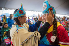 Jr. Miss Southern Ute, Autumn Sage helps Miss Southern Ute, Jazmine Carmenoros adjust her crown before the first Grand Entry of the Southern Ute Tribal Fair Powwow. 