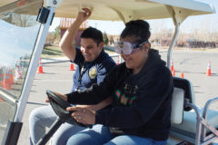 Nick Sanchez, SUPD Resource Officer, hangs on during a drive with Tanisha Figueroa. Figueroa tests out the drunk goggles — hitting multiple cones on her way around the course.
