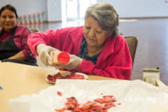 Southern Ute elder Evalyn Russell cuts and seasons pieces of buffalo meat to dry on Wednesday, October 23 at the Southern Ute Multi-Purpose Facility.