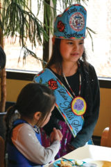 Little Miss Southern Ute, Shayne White Thunder shakes hands with Amonnie Johnson, a school student, during Southern Ute Indian Montessori Academy’s lunch on Friday, Jan. 24. 
