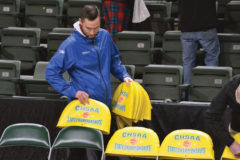 Colorado High School Activities Association Assistant Commissioner Justin Saylor commences removing event-specific chair-back covers late Thursday night, March 12, inside the Budweiser Events Center in Loveland, following CHSAA’s decision to terminate the State Basketball Championships – not just in Class 2A, but all classifications – due to precautions taken against the spread of/exposure to the global coronavirus outbreak.