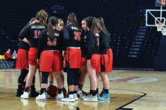 With practically no crowd behind them – due to restricted entry policies enacted in hopes of preventing possible COVID-19 exposure – the Ignacio Lady Bobcats listen to senior captain Makayla Howell’s final pre-game pump-up phrases prior to playing Holyoke in the Class 2A State Championships’ ‘Great Eight’ round Thursday night, March 12, inside the Budweiser Events Center in Loveland, Colo.