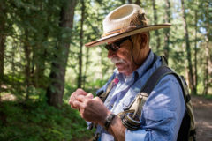 Fly fishing guide and columnist, Don Oliver, ties on a dry fly in anticipation of the morning ahead, fishing for trout along Lime Creek — one of his favorite haunts. 