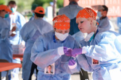 Staff working with International Medical Relief out of Loveland, Colo. ready their PPE at the beginning of the day.