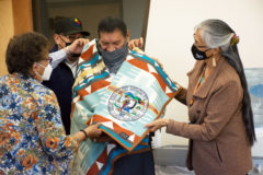 Tribal Council members: Ramona Eagle, Bruce Valdez and Linda Baker wrap Franklin “Frankie” Thompson in a Pendleton blanket in celebration of his retirement from the SkyUte Casino Resort on Tuesday, April 20. A small reception was held in Thompson’s honor at the Buckskin Charley Room in the Leonard C. Burch Building. 