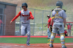 Ignacio’s Lawrence Toledo (20) speeds past Meeker catcher Peter Hanks, completing an inside-the-park home run during Game 1 of the Bobcats’ two-game sweep of the visiting Cowboys on Saturday, May 8.