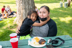 Candi and Ammonie Johnson cuddle together as they enjoy their food at the BGC End of Summer BBQ. 