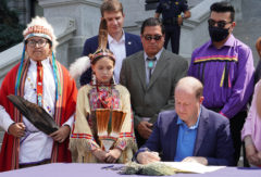 Tribal dignitaries stand with Gov. Jared Polis as he signs two executive orders rescinding proclamations, issued in 1864 by Territorial Governor John Evans, that led to the Sand Creek Massacre. Also pictured, from left to right: Jameson Blackbear, Southern Cheyenne and Arapaho Tribe; Jeanvieve Jerome of the Turtle Mountain Ojibwe and Lakota; Speaker of the House Alec Garnett, D-Denver; Reggie Wassana, Governor of the Cheyenne and Arapaho Tribe; and Jordan Dresser, chairman of the Northern Arapaho Tribe.   