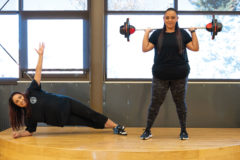 SunUte Community Center Group Exercise Instructors, Beth Santistevan and Jalisa Paul demonstrate how to plank and lift weights just as you would during one of their classes. 