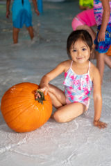 Southern Ute Indian Montessori Academy student, Kairi Ruybal proudly holds onto the pumpkin she chose to swim with and take home for the spooky holiday. The annual Pumpkin Splash event returned this year at the SunUte Community Center, Friday, Oct. 22.  

 