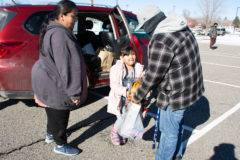 Boys and Girls Club Program Aide, Takoda Armstrong is handed a basketball and other toys from his daughter, Malina Armstrong and mother Kayla Armstrong during the “Fill the Bus” toy drive at the Sky Ute Casino Resort, Saturday, Dec. 11. 
