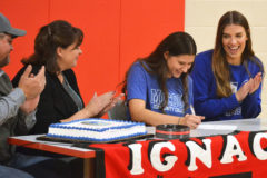 Applauded at left by father, Jason Pontine and mother/IHS Volleyball head coach Shasta Pontine, Ignacio senior Alexis Pontine completes her signing Monday, Dec. 13, of a National Letter-of-Intent to study at and play for McCook (Neb.) Community College, represented at right by assistant coach Hannah Emerson. 