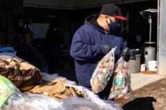 Micco Wesley, Custom Farm Field Supervisor with Southern Ute Agriculture helps distribute food items, including potatoes to tribal households, Friday, Feb. 10 at the Southern Ute Ag. Division building in Ignacio. These quality food items included beef roast, pork roast, hamburger, butter, potatoes, pancake mix, Adobe Milling beans, apple sauce, and large sacks of Blue Bird flour. Remaining supplies were made available at Pine River Shares, at the Ignacio ELHI, the following day.  