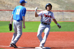 With Westcliffe-based Custer County third baseman Zach Fischer (11) looking on, Ignacio's Nate Hendren (6) celebrates his pinch-hit RBI-triple during Game 2 of the Bobcats' April 2 home doubleheader. Hendren's hit brought in IHS' only run in the contest. 