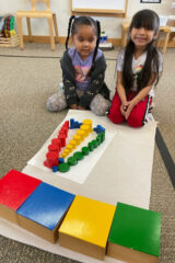 Shawnee Rizzo and Ava Naranjo work with the knobless cylinders in their classroom. These cylinders are typical Montessori materials that support the learning of geometric patterns along with increasing vocabulary with words such as thick, thin, height and circumference. 