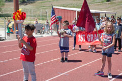 Ignacio Elementary first graders lead the the second grade class, during the March of Champions, as they make their way around the Ignacio Sports Field to begin Field Day.