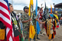 Ute Mountain Ute veteran Gordon Hammond (USMC) shakes the hand of Ute Mountain Ute Little Brave, Kiowan Cantsee prior to Saturday evening’s Grand Entry. The Color Guard comprised of Ute Mountain and Southern Ute veterans led the dancers into the powwow arbor included, left to right, Grace Jacket (Army), Raymond Curley (USMC), Hammond, and Southern Ute Veteran’s Association members, Bruce LeClaire (Army) and Howard Richards Sr. (Army).