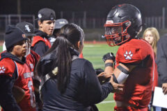 With concerned Bobcats observing, Ignacio trainer Shelby Sangster patches up senior quarterback John Riepel's non-throwing elbow Friday night, Oct. 14, during a 54-6 home loss to Monte Vista.