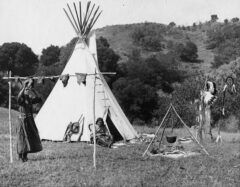 Photo of the scene outside of a tipi. Photo by Clyde W. Champion, 1928. History Colorado. 86.392.88 