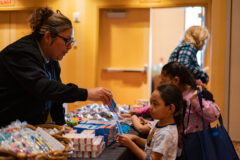 Southern Ute Health Center Dental Assistant, Lavera Holly hands out a box of tooth paste to a Southern Ute Indian Montessori Academy Student on Thursday, Nov. 17 at the Sky Ute Casino Events Center.   