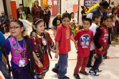 Students and dancers hold hands at the Ignacio Intermediate School for a round dance to close out a cultural dance presentation. The Southern Ute Heritage Dancers gave presentations throughout Ignacio on Tuesday, Nov. 20 in celebration of Native American Heritage Month. This photo first appeared in the November 30, 2012, edition of the Southern Ute Drum.  