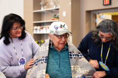 Southern Ute Council Member, Vanessa Torres and Vice-Chairman, Lorelei Cloud wrap tribal elder Vida B. Peabody in a Pendleton blanket given as a gift for her 93rd birthday. Peabody is currently the eldest tribal member in the Southern Ute Tribe.  