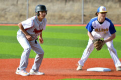 Kept honest by Dove Creek's Taber DeJane (33), Ignacio freshman Sonny Flores leads off second base during season-opening action Thursday, March 16, at IHS Field. The Bobcats routed the Bulldogs, 14-4 and 10-0. 