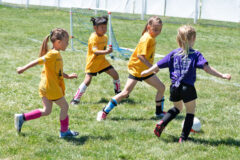 Remi Lundberg, Allyiannah Tahlo and Selah Bagdol of team “Goldfish,” hustle to block an opponent moving in for the score in Pre-K/Kindergarten soccer play, Saturday, April 29.
