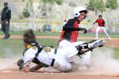 Ignacio's Phillip Quintana rises after sliding safely into home plate, beating an off-line throw to Pagosa Springs catcher Hunter Pouyer (4) during non-league play Thursday, May 11, at PSHS. The Bobcats lost to the 3A Pirates but ended the regular season winning twice on the 13th at 2A Custer County. 