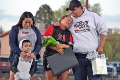 Ignacio senior Sierra Red (21) gets a squeeze from father Adam during a lengthy Senior Day halftime recognition Thursday, May 4, at IHS Field. With nine saluted seniors – literally half of the roster – in uniform, IHS hosted 3A Bayfield that night but fell 5-1. 
