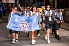 Proudly carrying the Southern Ute tribal flag, Team Colorado athletes and coaches make their way through downtown Halifax, Nova Scotia where spectators lined the streets in anticipation of the 2023 North American Indigenous Games, Sunday, July 16. 