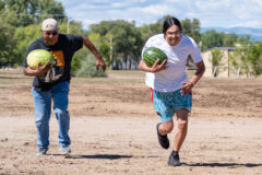 Southern Ute elder Byron Frost puts his best foot forward in an attempt to best the competition during the Watermelon Foot Race, despite muddy conditions on the track.  