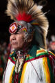 Thumbnail image of Randy Medicine Bear, dressed in full regalia, stands in with the Southern Ute Veterans Association on day one. Medicine Bear has served as an arena director for numerous powwows over the years, and calls Loveland, Colo. his home.